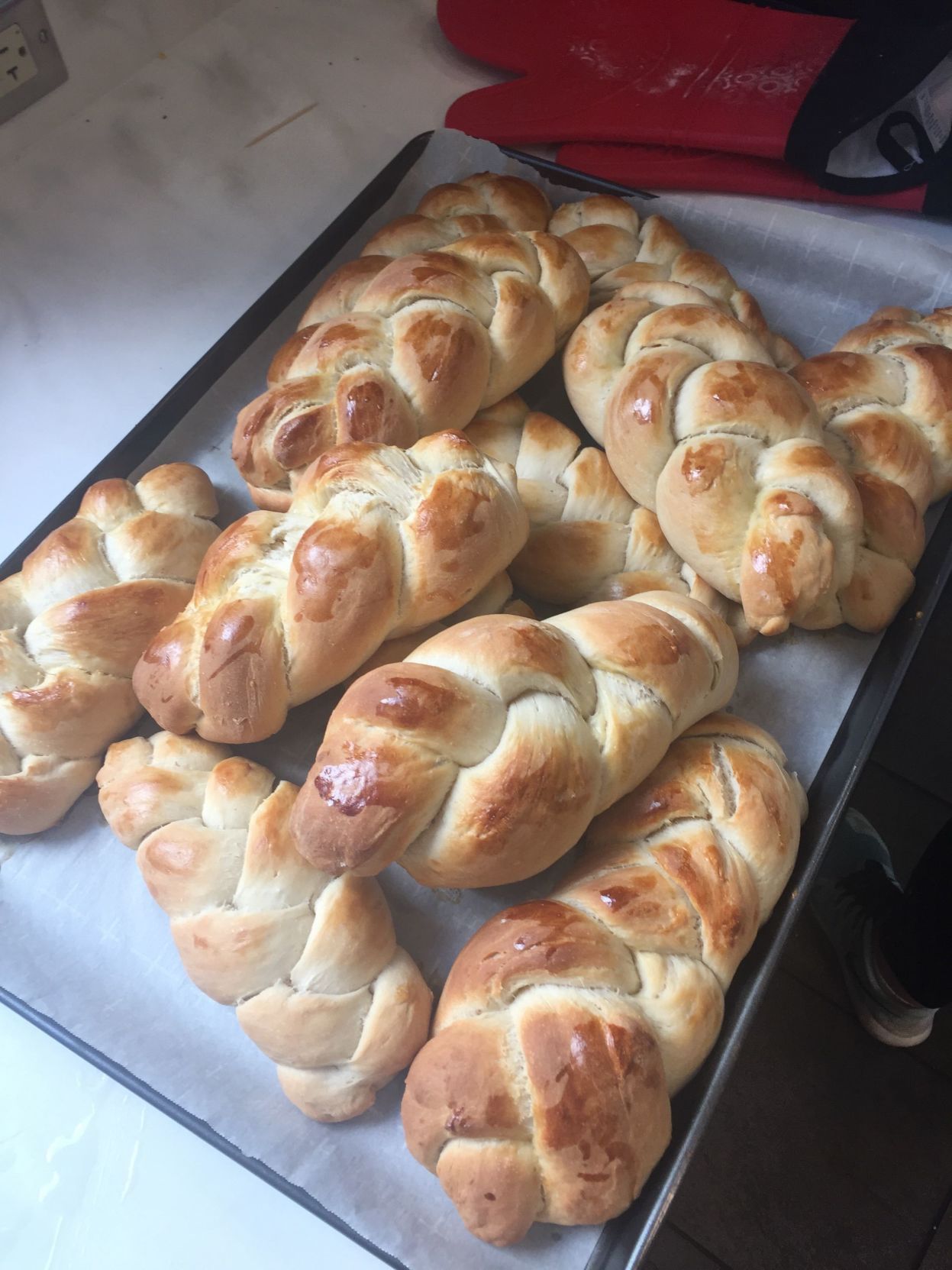 A tray of freshly-baked challah bread sits on a kitchen counter